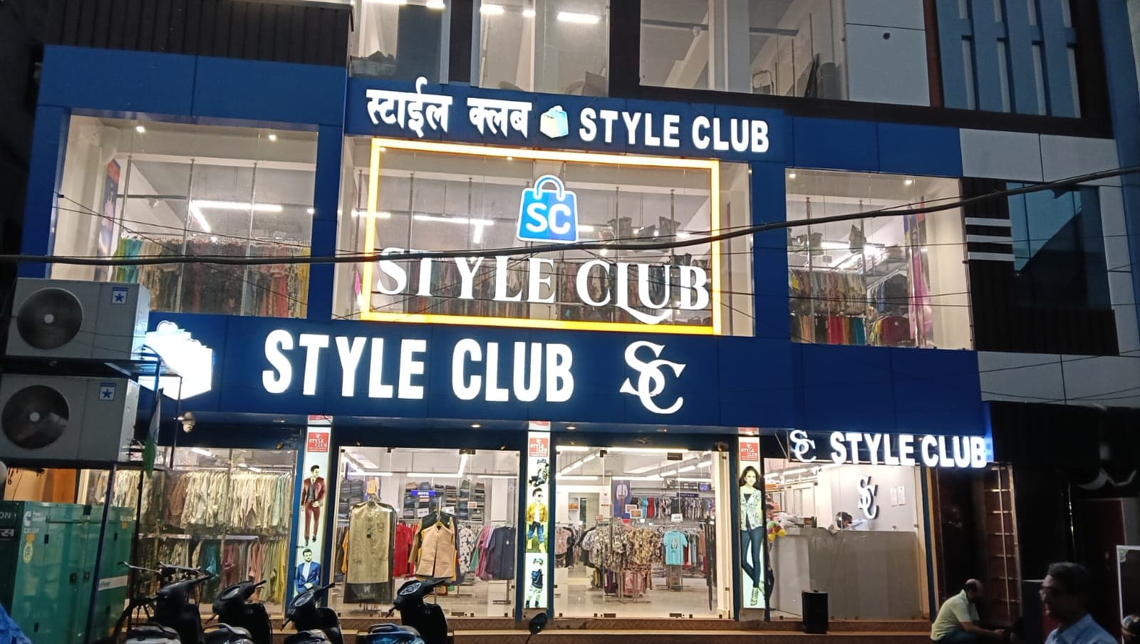 Style Club storefront at Netram Chauraha, Katra, lit up at dusk